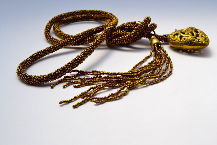 THICK GOLD BEAD WRAP TIED BOTTOM NECKLACE W CARVED HOLLOW HEART & MULTIPLE GOLD STRAND TASSELS